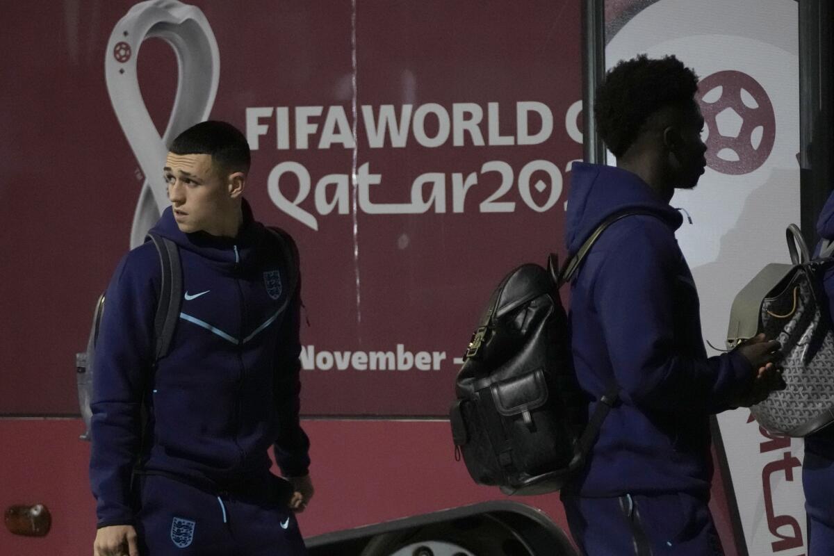 Phil Foden (izquierda) y Bukayo Saka, de la selección de Inglaterra, abordan un autobús en el aeropuerto de Doha