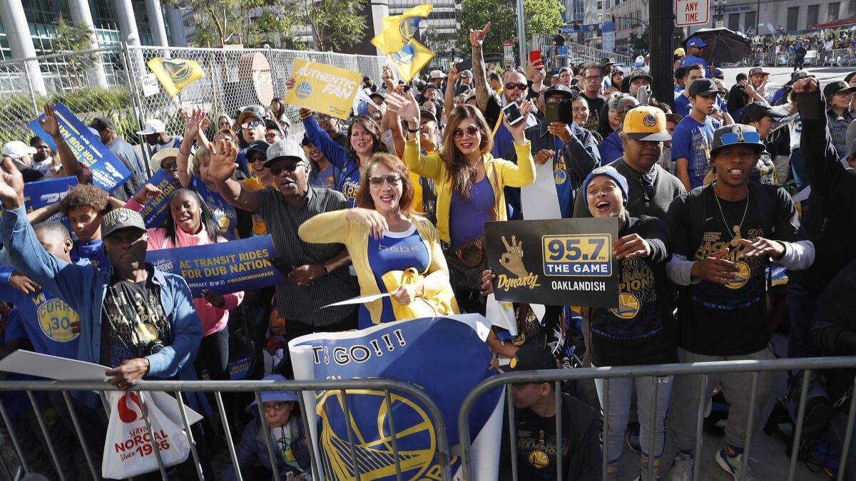 Fans in Oakland wait for the parade honoring the Golden State Warriors to start on June 12.