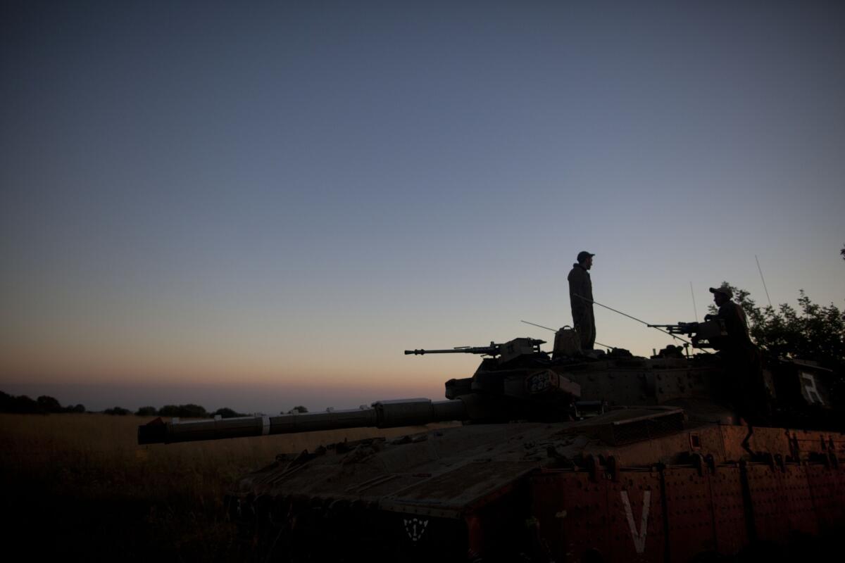 Israeli soldiers with a tank on the border with Syria on Sunday. An Israeli teen was killed and three adults were wounded in an attack near the border. Later, Israeli airstrikes hit nine military targets in Syria.