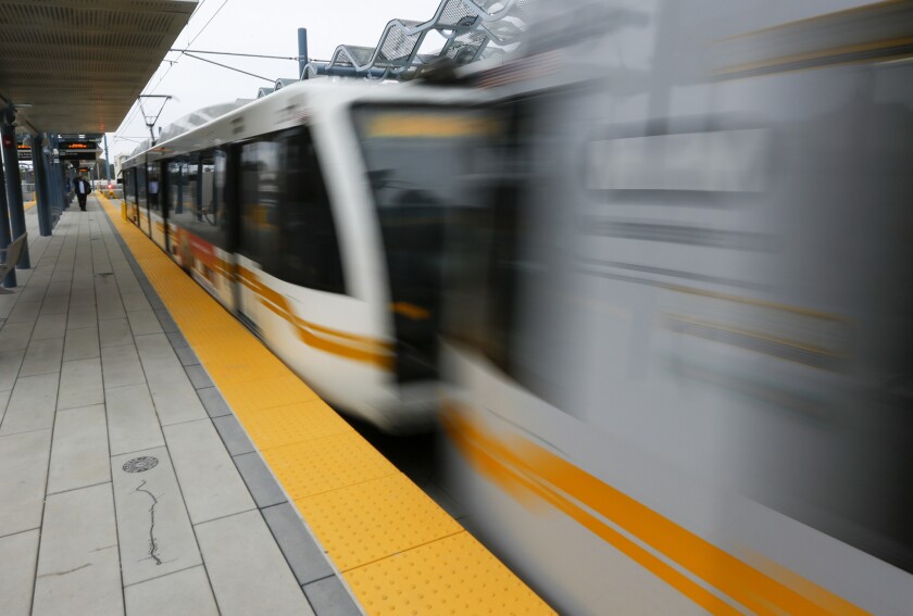 An Expo Line train on a practice run to downtown Los Angeles whizzes past a station last month. Metro is seeking a half-cent sales tax increase in November to fund billions of dollars in new projects in the coming decades.