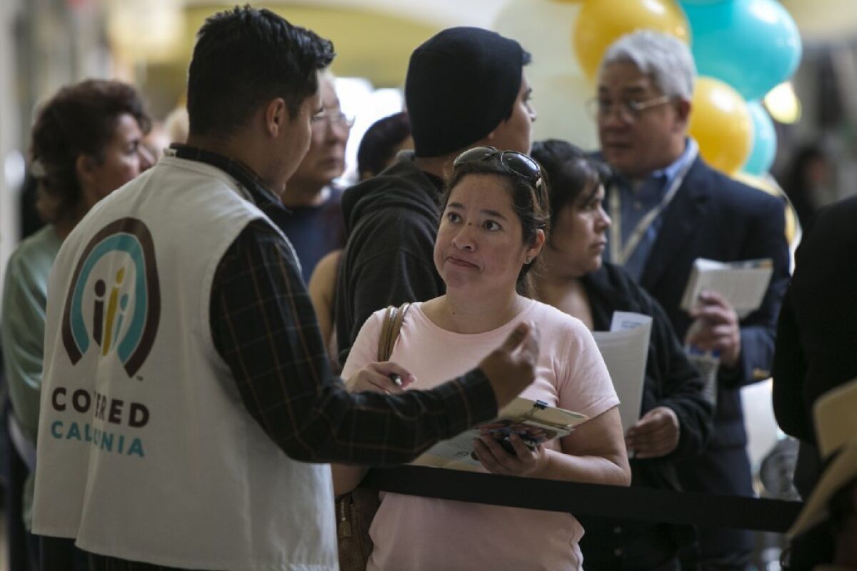 Open enrollment for health coverage under the Affordable Care Act runs Nov. 1 to Jan. 31. Above, people wait to sign up at a Covered California event in Panorama City last year.
