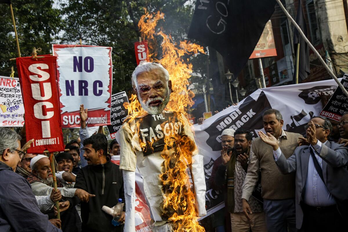 Members and activists Socialist Unity Center of India-Marxist (SUCI-M) burn an effigy of Indian Prime Minister Narendra Modi.
