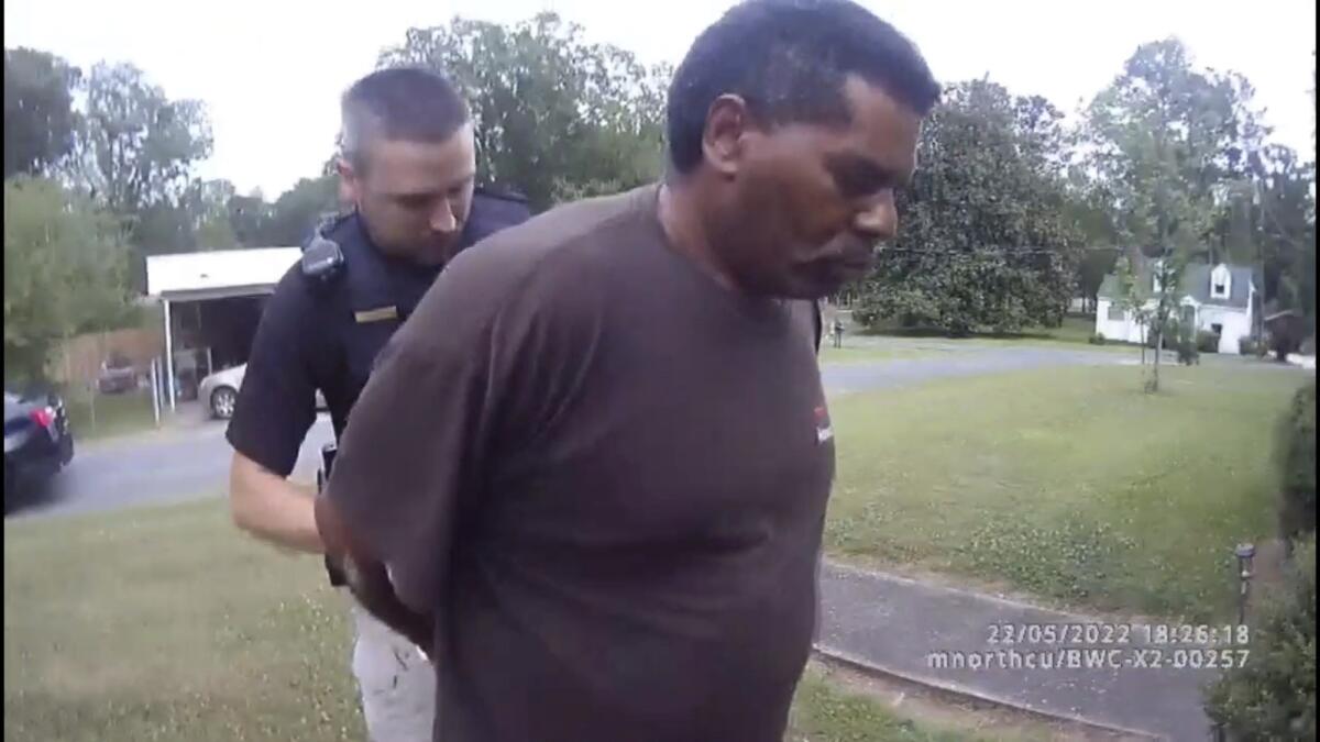 This image captured from bodycam video released by the Childersburg (Ala.) Police Department and provided by attorney Harry Daniels shows Michael Jennings, right, in custody in Childersburg, Ala., on Sunday, May 22, 2022. Jennings was helping out a friend by watering flowers when officers showed up and placed him under arrest within moments. (Childersburg Police Department via AP)