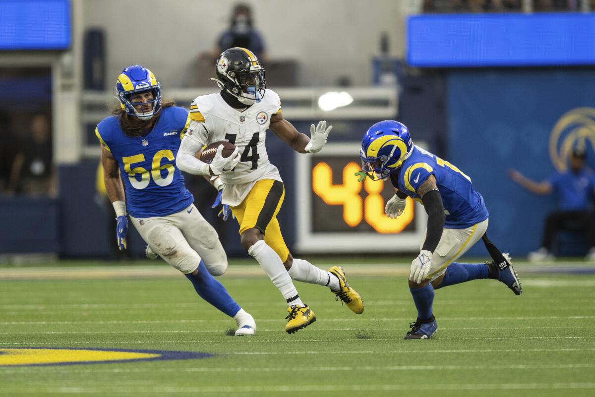 Pittsburgh Steelers wide receiver George Pickens (14) runs with the ball as Rams cornerback Cobie Durant (14) chases.