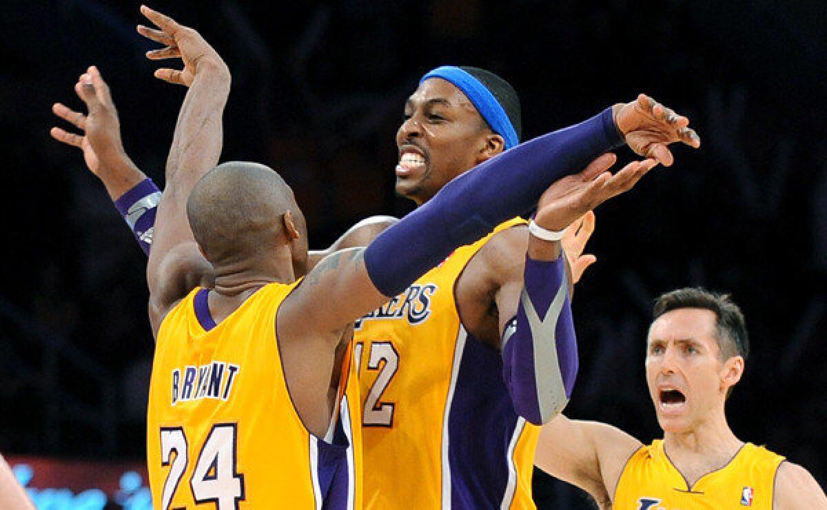 Kobe Bryant, left, celebrates with the teammate Dwight Howard, center, as Steve Nash looks on during a game against the Utah Jazz.