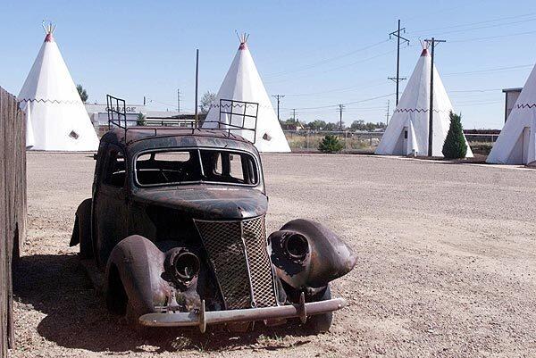 An old car is parked next to the Wigwam Village Motel office in Holbrook, Ariz., in a 1999 photo.