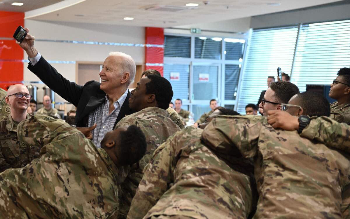 President Joe Biden takes a selfie with service members from the 82nd Airborne Division in Rzeszow in southeastern Poland.