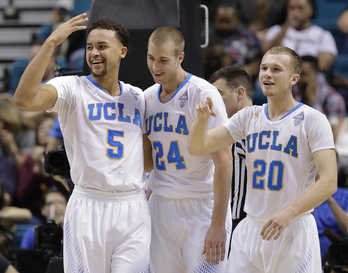 Teammates Kyle Anderson (5) and Bryce Alford (20) celebrate after Bruins forward Travis Wear scored in the second half of a Pac-12 Conference tournament game against Oregon on Thursday night in Las Vegas.