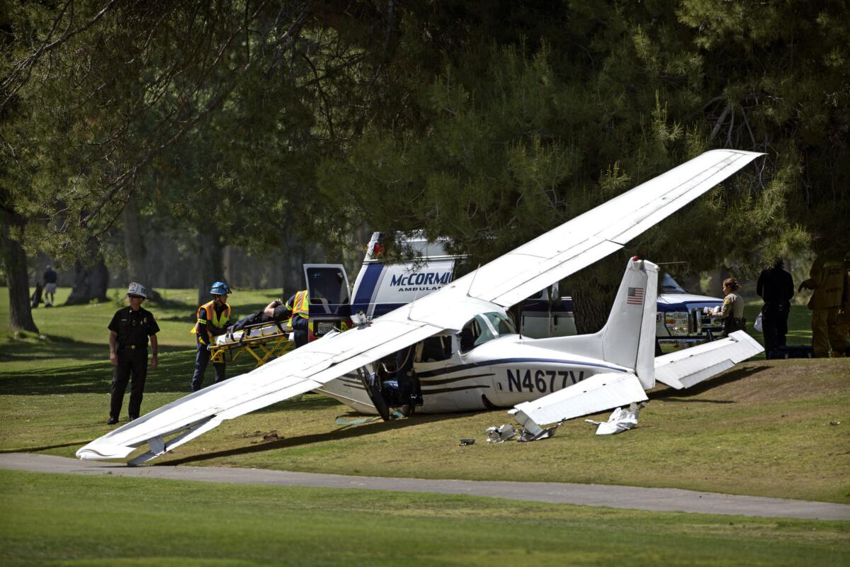 A victim is loaded into an ambulance at the scene of a single-engine plane crash at Westlake Golf Course.