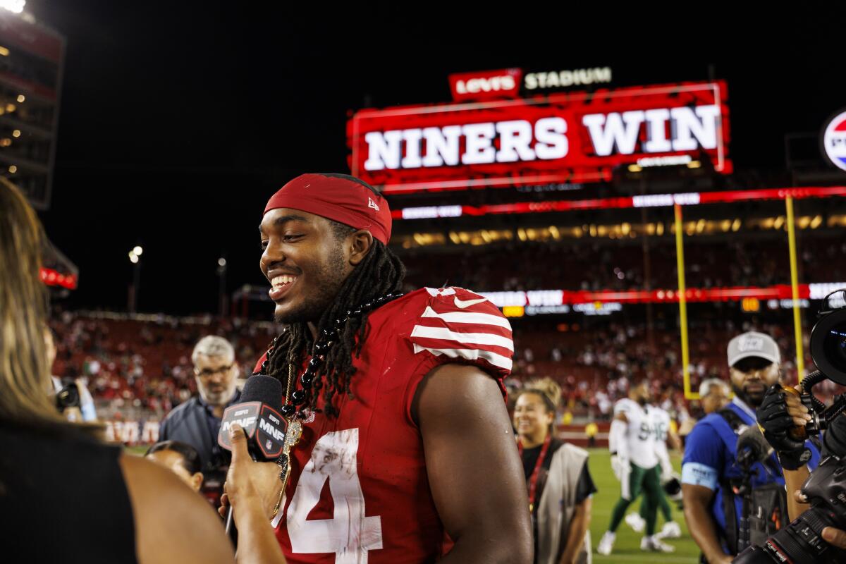 Jordan Mason of the San Francisco 49ers talks with an ESPN reporter after an NFL football game.