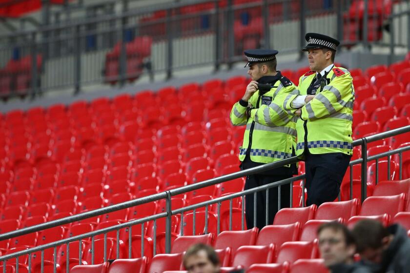 British police officers on duty at Wembley Stadium in London on Nov. 16, 2015, as French players train on the pitch ahead of their international friendly football match against England.