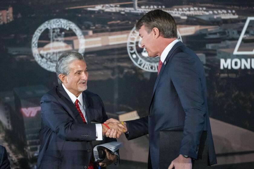 FILE -Ted Leonsis, left, owner of the Washington Wizards NBA basketball team and Washington Capitals HNL hockey team, shakes hands with Virginia Gov. Glenn Youngkin as they announce plans for a new sports stadium for the teams, Wednesday, Dec. 13, 2023, in Alexandria, Va. Top legislators in the Virginia House of Delegates say Republican Gov. Glenn Youngkin is mischaracterizing and “embellishing” a key part of the speech he’s been giving around the state since the Democratic-controlled General Assembly left town without approving his proposal to lure two pro sports teams to Alexandria.(AP Photo/Alex Brandon, File)