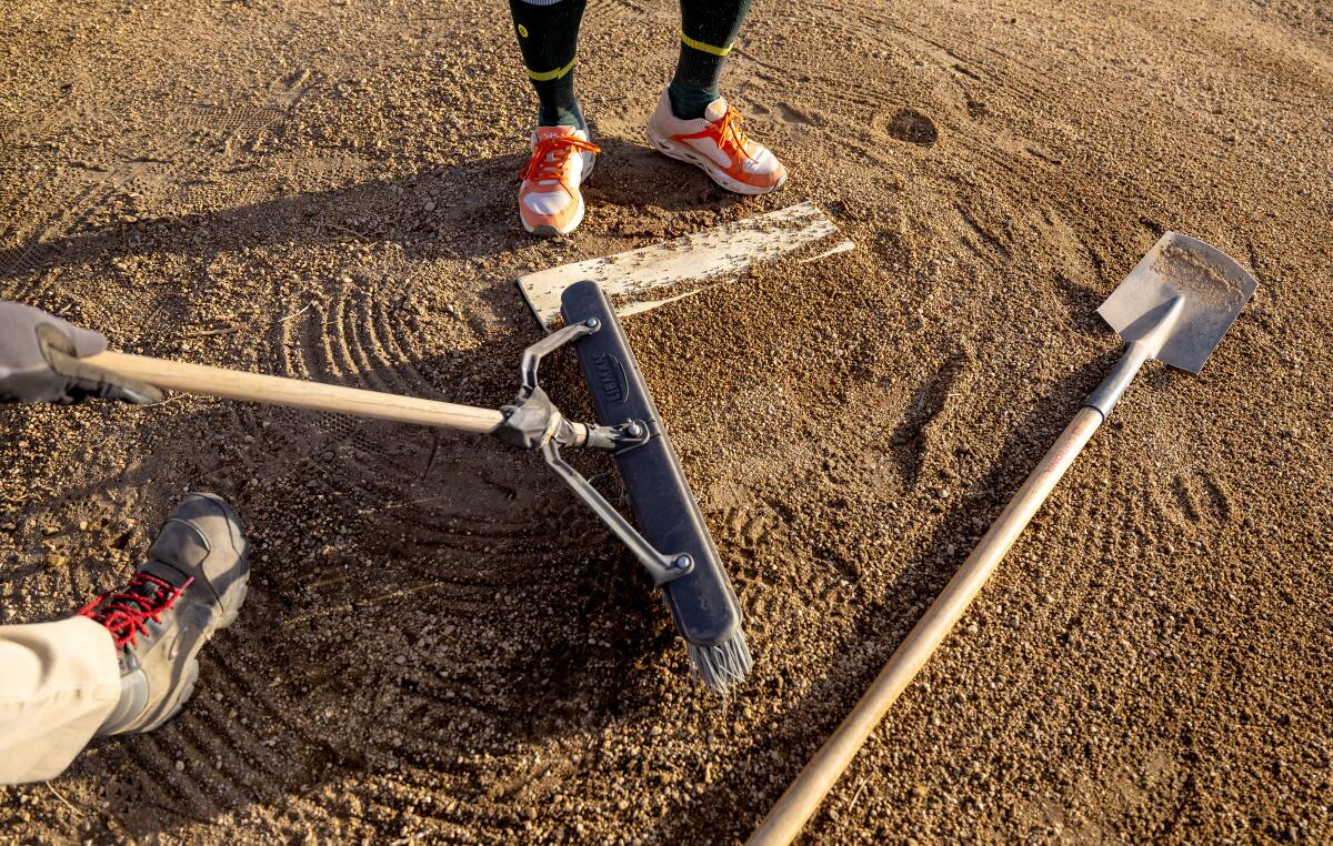 A grounds crew team preps the baseball field at Manzanar