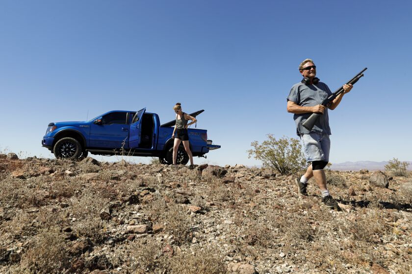 NEEDLES, CA - JULY 16, 2019 Ñ Needles Councilman Tim Terral, right, and his wife Holly Terral shoot in the desert two miles outside of town. The councilman put forth a resolution to declare the town a sanctuary city for the second amendment as part of a larger effort to loosen gun laws in Needles. (Irfan Khan / Los Angeles Times)