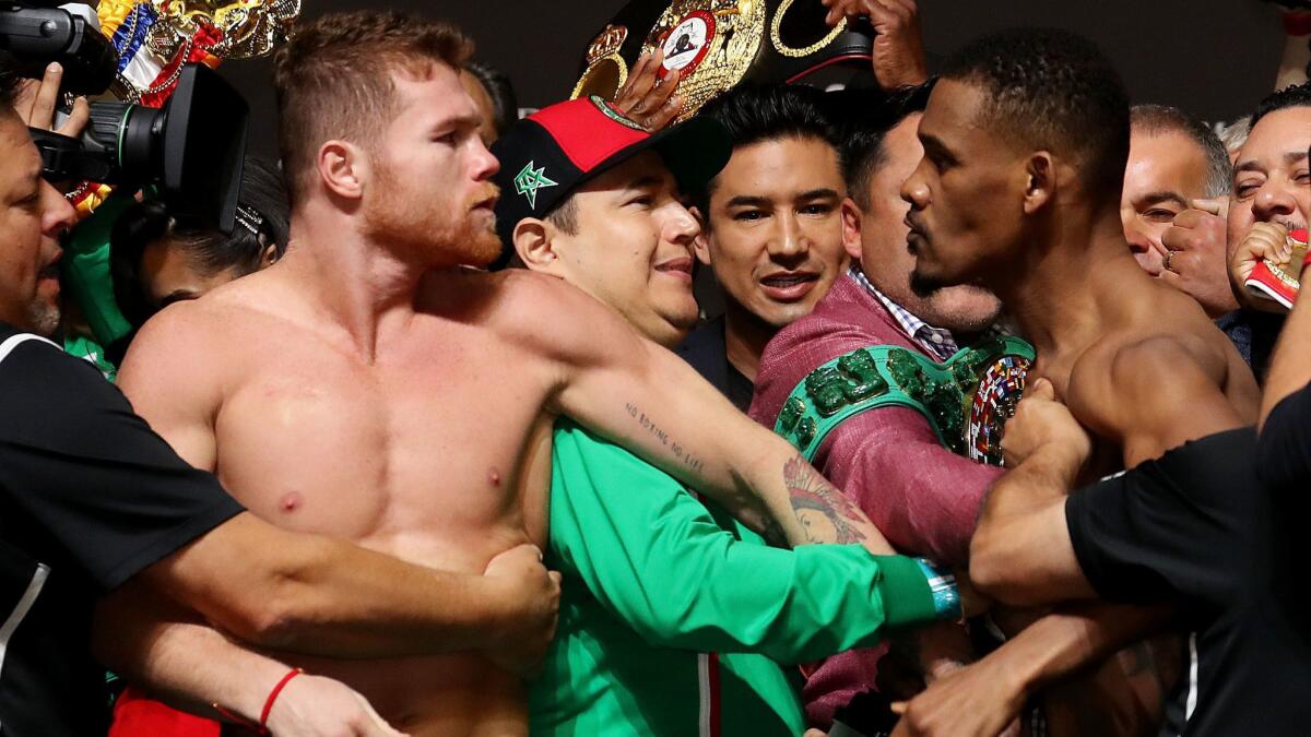 Canelo Alvarez and Daniel Jacobs get into a shoving match during their official weigh in at T-Mobile Arena.