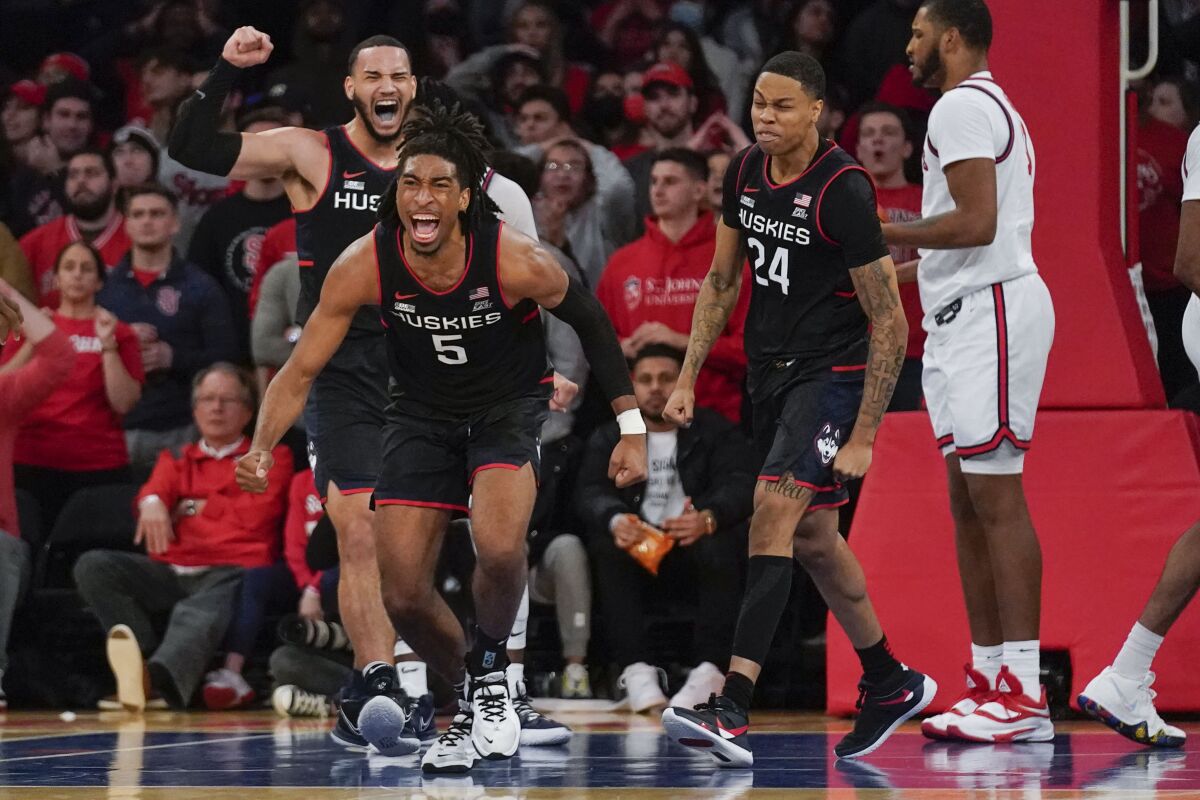 Connecticut's Isaiah Whaley (5), second from left, reacts after being fouled on his way to the basket during the second half of an NCAA college basketball game against St. John's, Sunday, Feb. 13, 2022, in New York. (AP Photo/Seth Wenig)