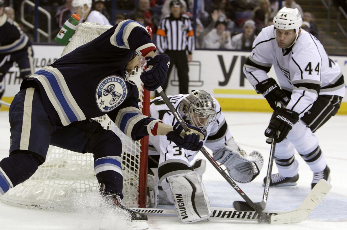 Kings goalie Jonathan Quick makes a save against Columbus Blue Jackets' Nick Foligno, left, as Robyn Regehr waits for the rebound on Monday night.