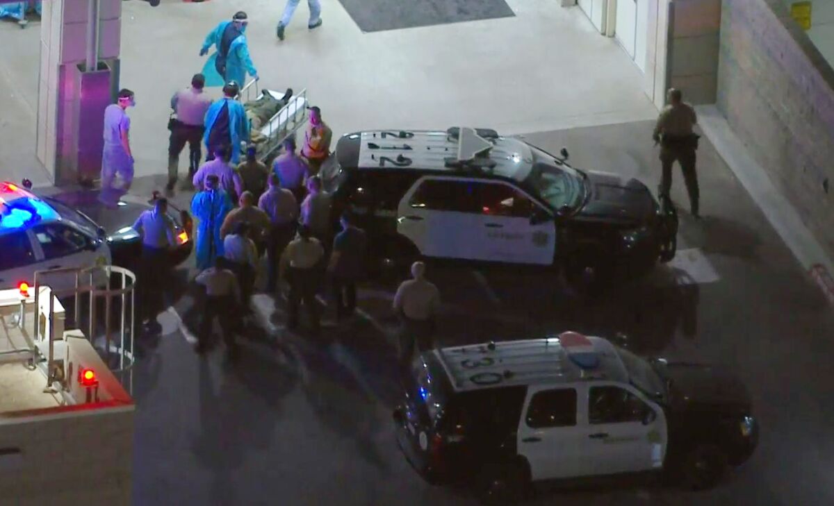 Medical staff attend to a Los Angeles County sheriff's deputy after another deputy accidentally shot her in the leg.