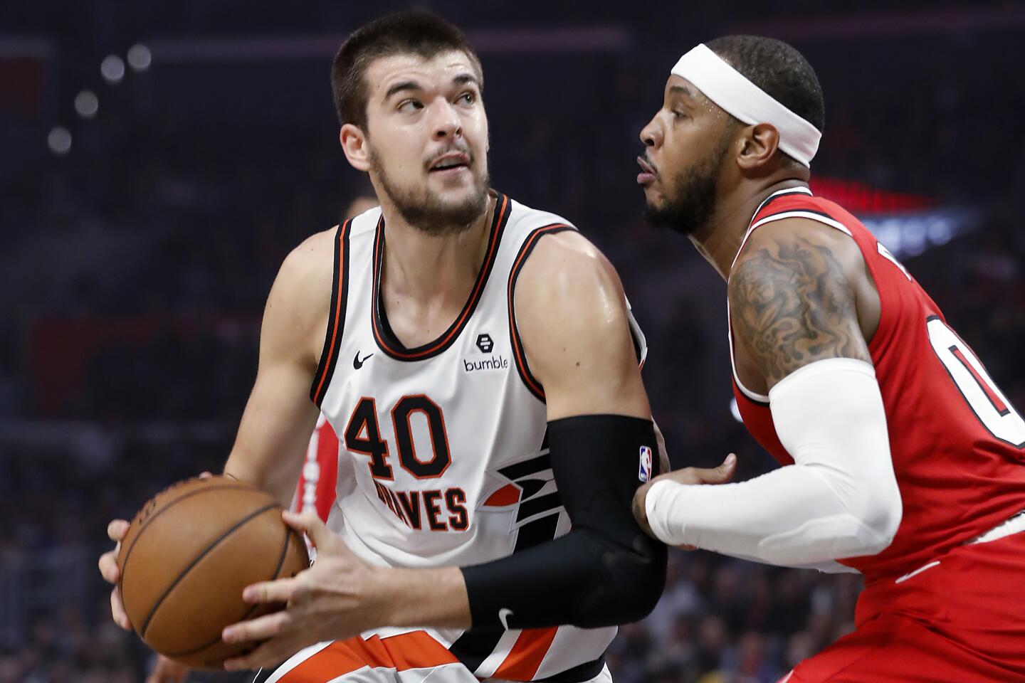 Clippers center Ivaca Zubac, left, turns to the basket against Portland Trail Blazers forward Carmelo Anthony in the first quarter at Staples Center on Tuesday.