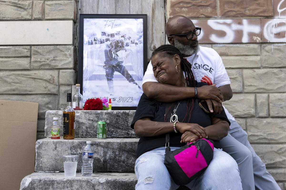 Antonio Lee's mother is comforted while mourning her son at a vigil.