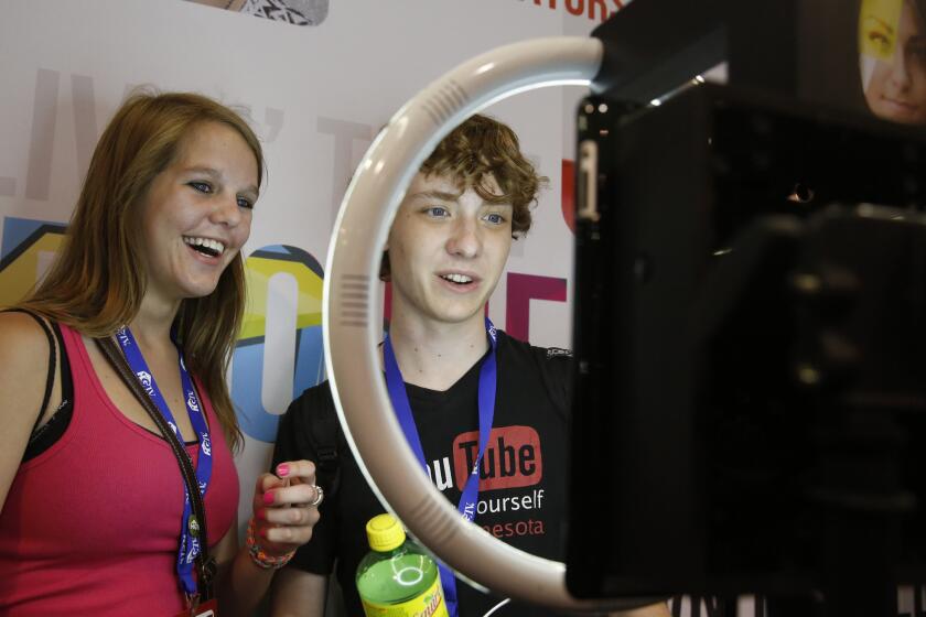 Friends Abby Ceaglske, 17, and Zack Nelson, 17, both from Minnesota, make a 3-second "GIF" video of themselves at the Full Screen booth at the Anaheim Convention Center during Vidcon.