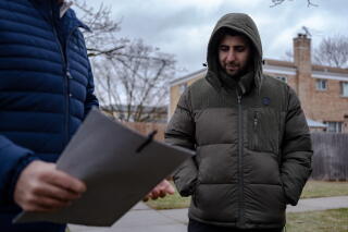 Abdulhaq Sodais, right, listens to Adriano Gasparini, a housing manager with RefugeeOne, after viewing potential apartments.