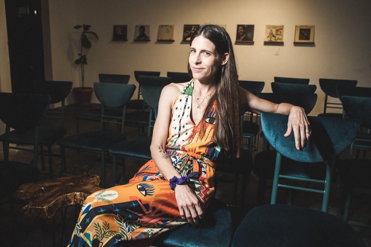 Nicole Blaine sitting on handmade chairs inside The Crow Comedy Club