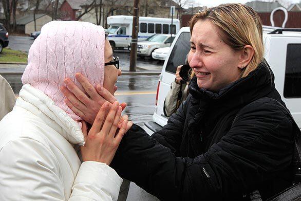 Survivor Zhanar Tokhtabayeva, 30, left, from Kazakhstan, embraces an unidentified woman in Binghamton, N.Y. A gunman opened fire on an immigration center earlier in the day, killing 13 before apparently committing suicide.