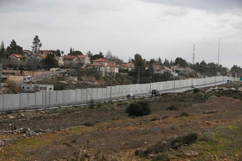 A view in the West Bank city of Ramallah shows Israel's controversial separation barrier and the settlement of Beit El behind it.