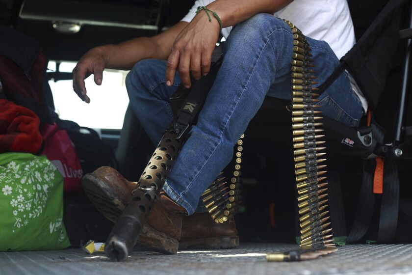 Un miembro del grupo de autodefensas Pueblos Unidos está sentado con sus municiones 