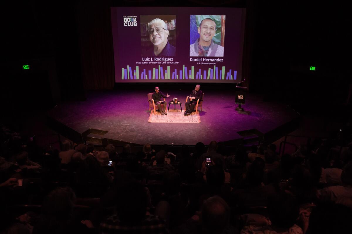 Times writer Daniel Hernandez, seated left, interviews author and poet Luis J Rodriguez.