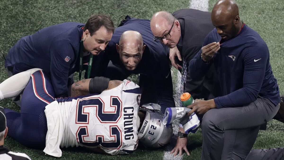 Patriots safety Patrick Chung is helped by medical staff after suffering an arm injury Sunday.