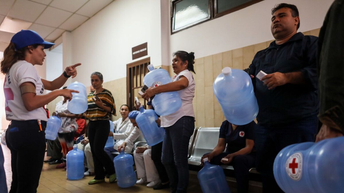 Red Cross workers deliver water purification kits to people in Caracas, Venezuela.