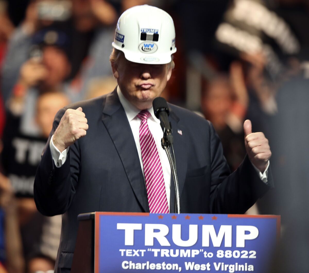 Republican presidential candidate Donald Trump puts on a miners' hard hat during a rally in Charleston, W.Va.