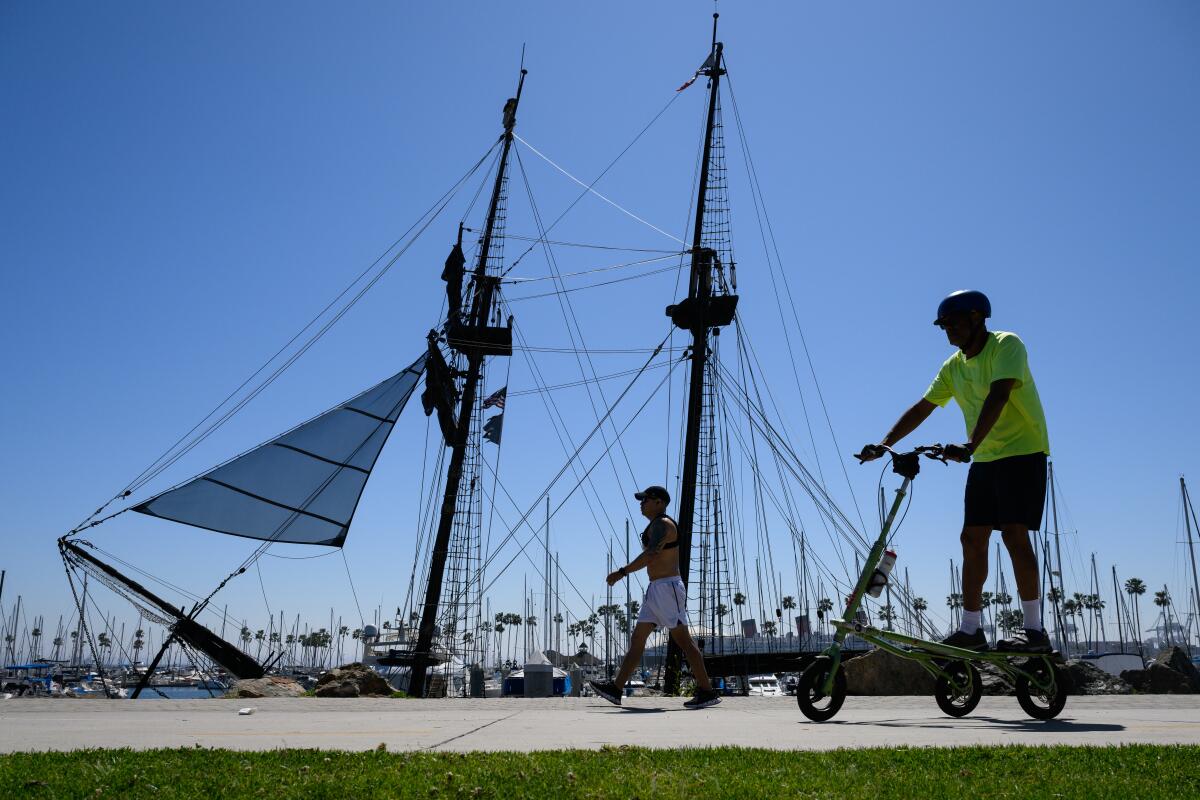 People enjoy the sun down by Shoreline Village during a hot day in Long Beach.