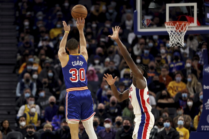 El jugador de los Warriors de Golden State Stephen Curry (30) lanza contra el jugador de los Pistons de Detroit Isaiah Stewart (28) en la primera mitad de su juego de NBA en San Francisco, el martes 18 de enero de 2022. (AP Foto/Jed Jacobsohn)