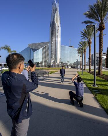A man takes a picture of the Christ Cathedral.