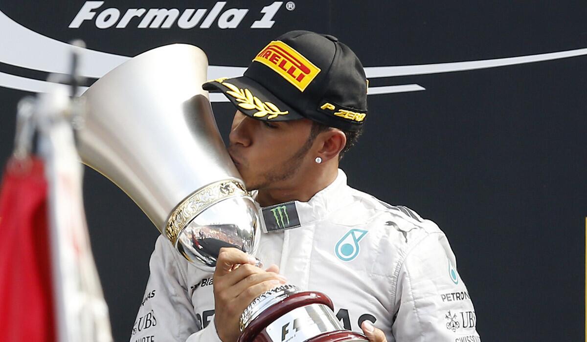 Formula One driver Lewis Hamilton celebrates on the podium Sunday after winning the Italian Grand Prix.