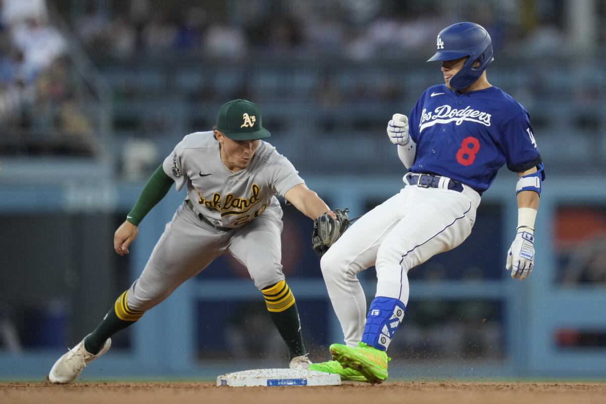 The Dodgers' Kiké Hernández pulls into second on a double ahead of a tag by Oakland's Zack Gelof.