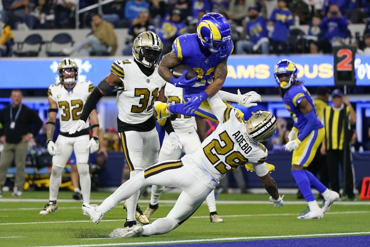 Rams running back Kyren Williams leaps over New Orleans Saints cornerback Paulson Adebo.