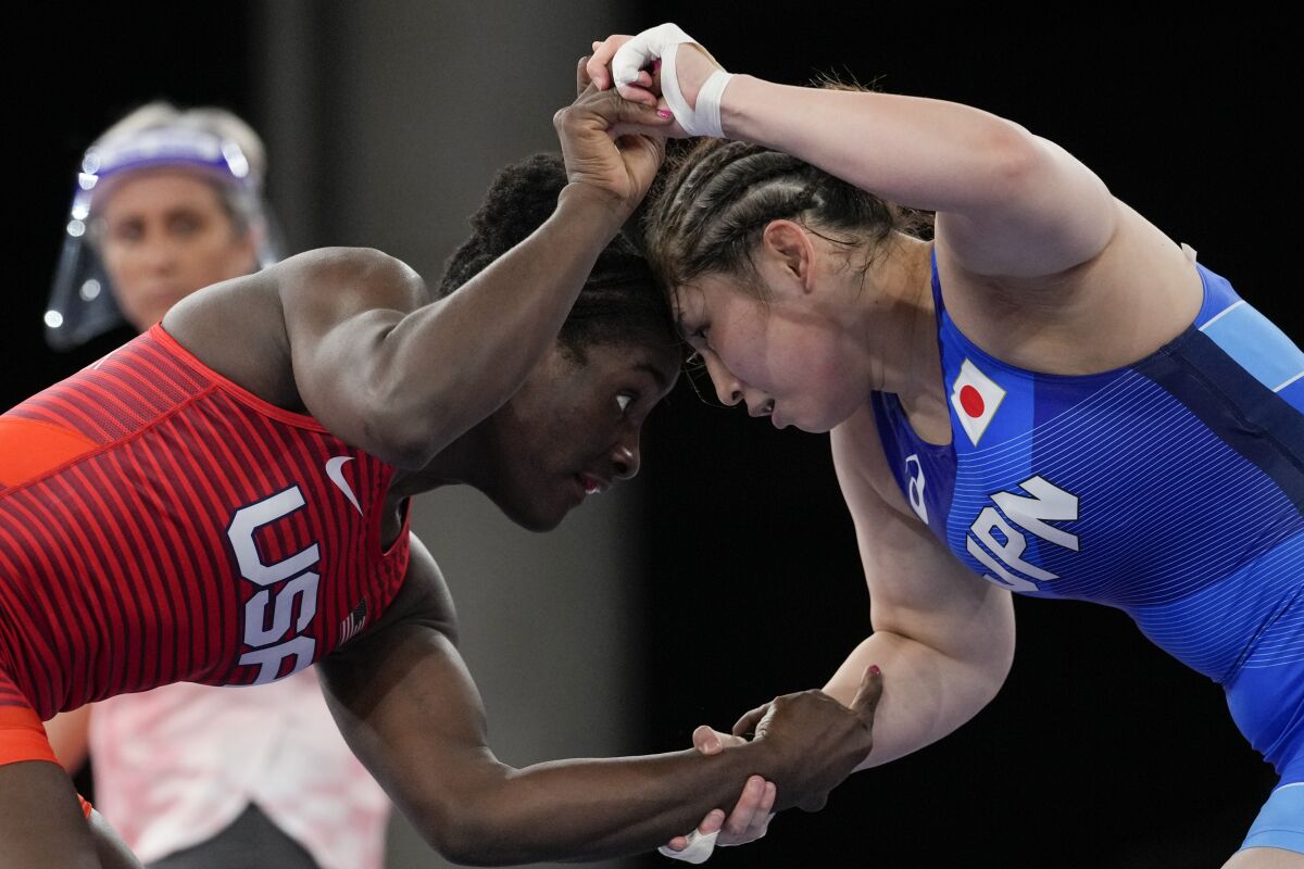 FILE - In this Aug. 2, 2021, file photo, United States' Tamyra Marianna Stock Mensah, left, and Japan's Sara Dosho compete during the women's 68kg freestyle wrestling match at the 2020 Summer Olympics in Chiba, Japan. Tokyo Olympians are exercising extraordinary discipline against the coronavirus. They are sealed off in a sanitary bubble that has made competition possible but is also squeezing a lot of fun from their Olympic experience. (AP Photo/Aaron Favila, File)
