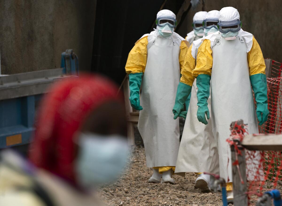 Health workers dressed in protective gear begin their shift at an Ebola treatment center in Beni, Democratic Republic of Congo, in July.