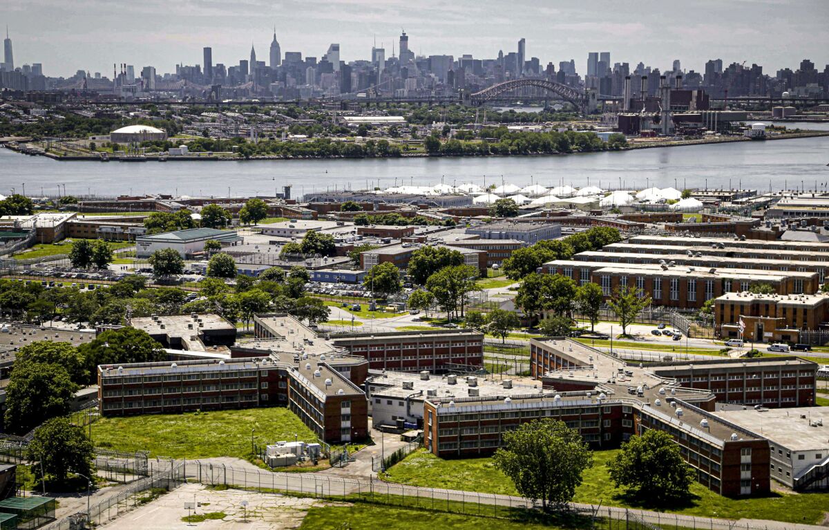 FILE - This Tuesday Dec. 2, 2014, file photo shows the Rikers Island jail complex in the foreground within the East River and the New York skyline in the background. Nearly all female and transgender inmates at New York City’s Rikers Island jail complex will be moved to state lockups in nearby Westchester County to relieve strain on the city’s failing jails, Gov. Kathy Hochul said Wednesday, Oct. 13, 2021.(AP Photo/Seth Wenig, File)