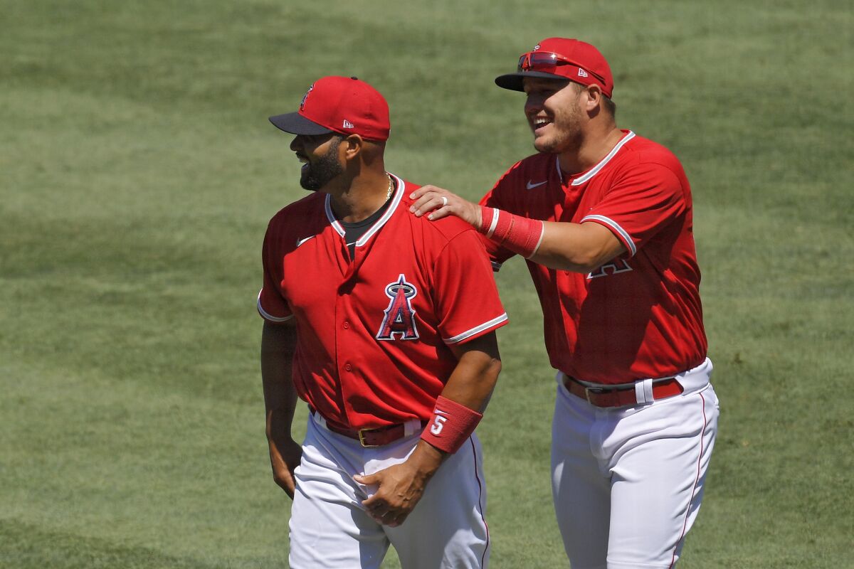 Albert Pujols, left, and Mike Trout joke around prior to an intrasquad game July 13 at Angel Stadium.