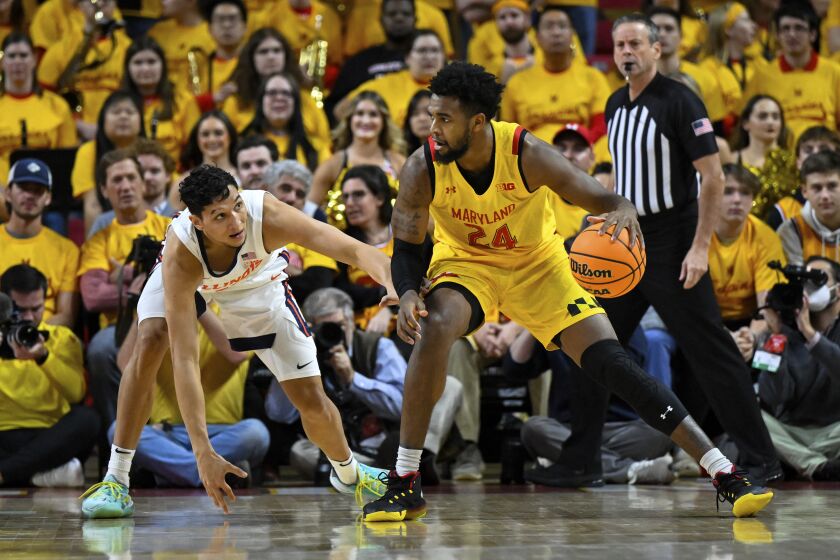 Maryland forward Donta Scott (24) handles the ball against Illinois guard RJ Melendez during the first half of an NCAA college basketball game, Friday, Dec. 2, 2022, in College Park, Md. (AP Photo/Terrance Williams)