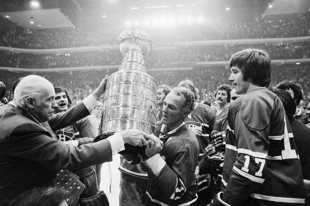 NHL president Clarance Campbell hands the Stanley Cup to Canadiens captain Henri Richard in 1973.