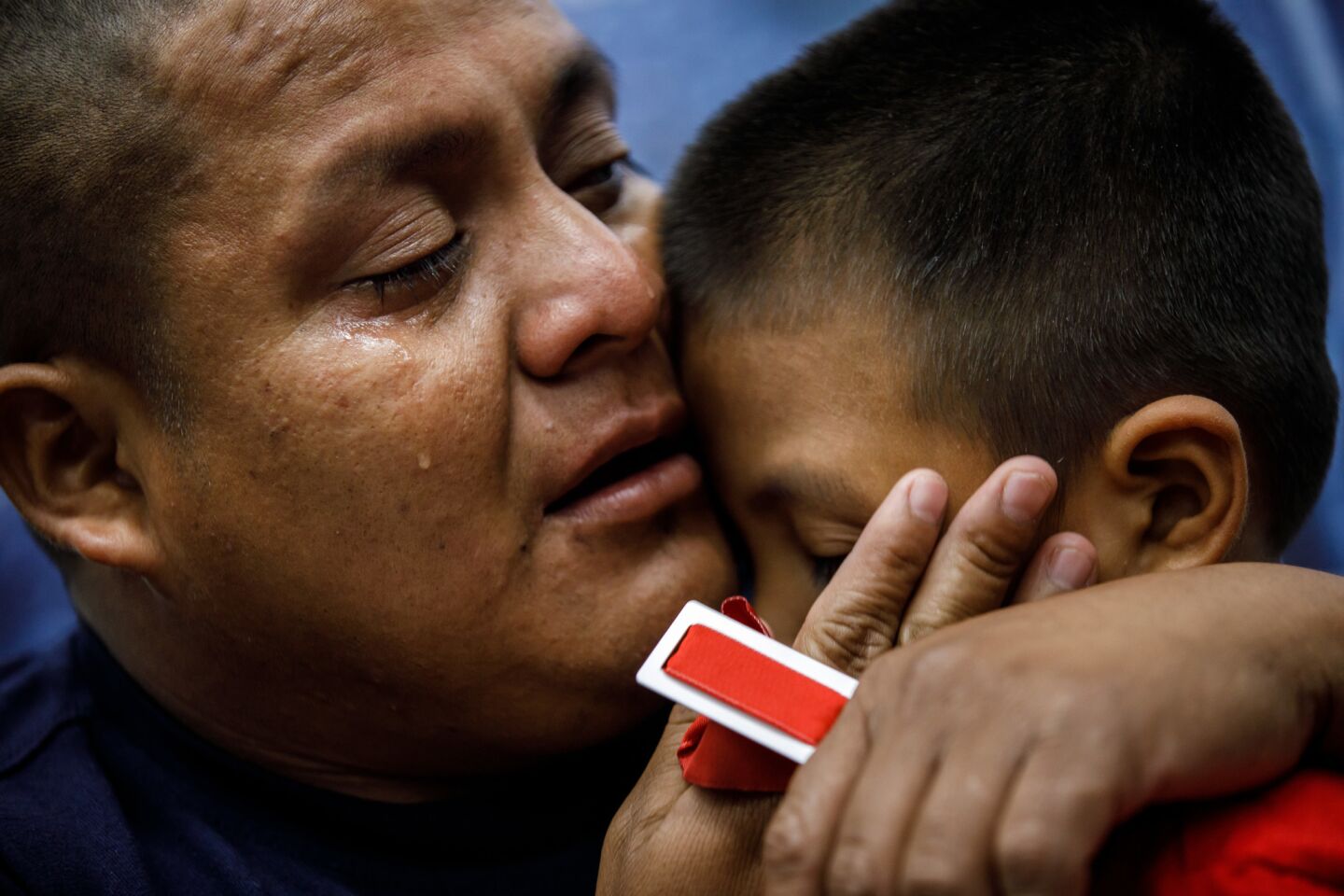 Guatemalan asylum seeker Hermelindo Che Coc cries as he reunites with his son, Jefferson Che Pop.