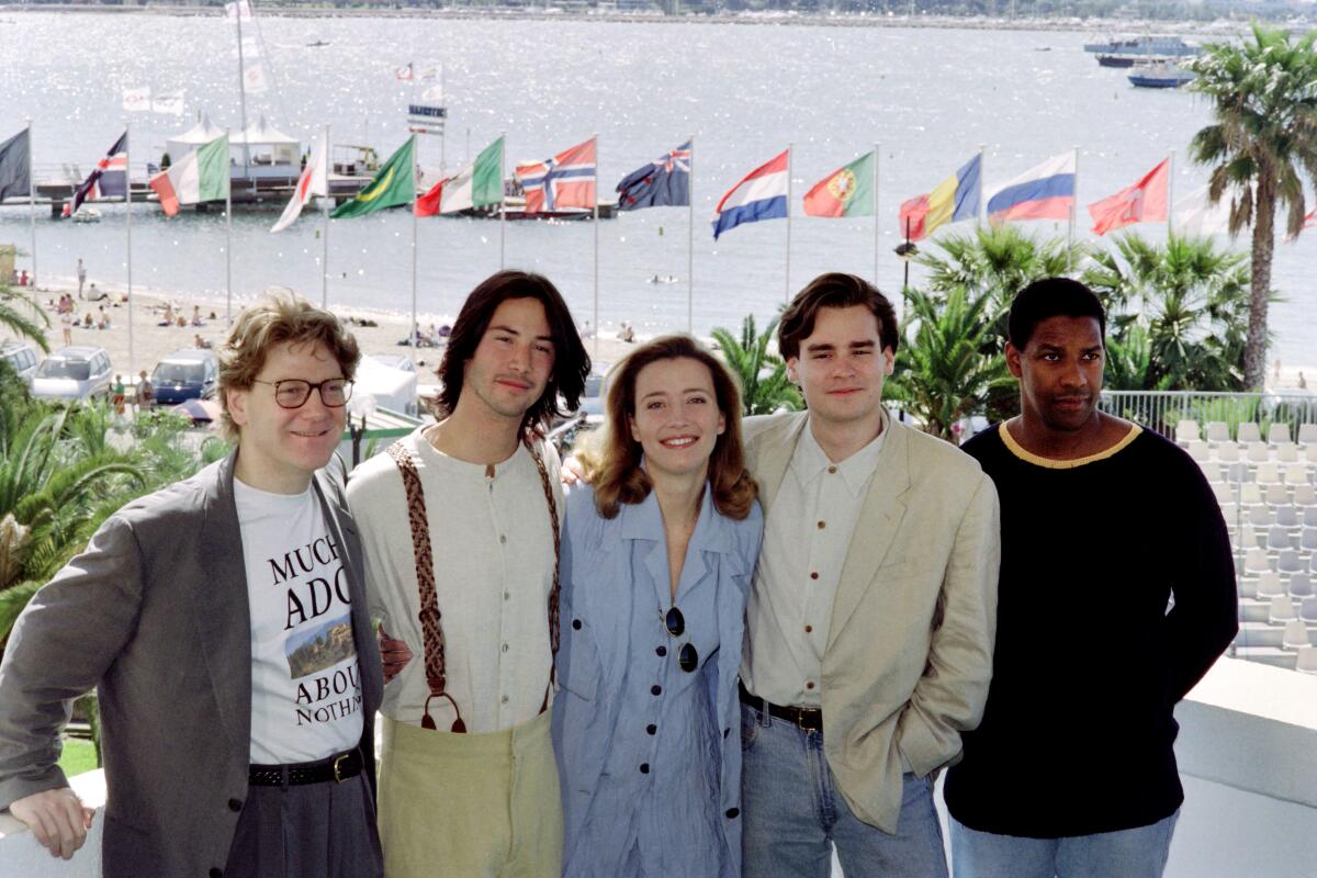 Several film collaborators pose in front of a beach and harbor.