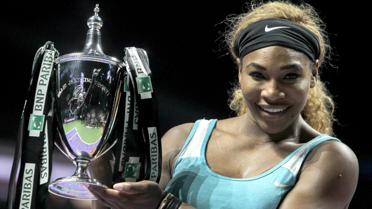 Serena Williams poses with the Billie Jean King Trophy after defeating Simona Halep in the WTA Finals in Singapore on Sunday.