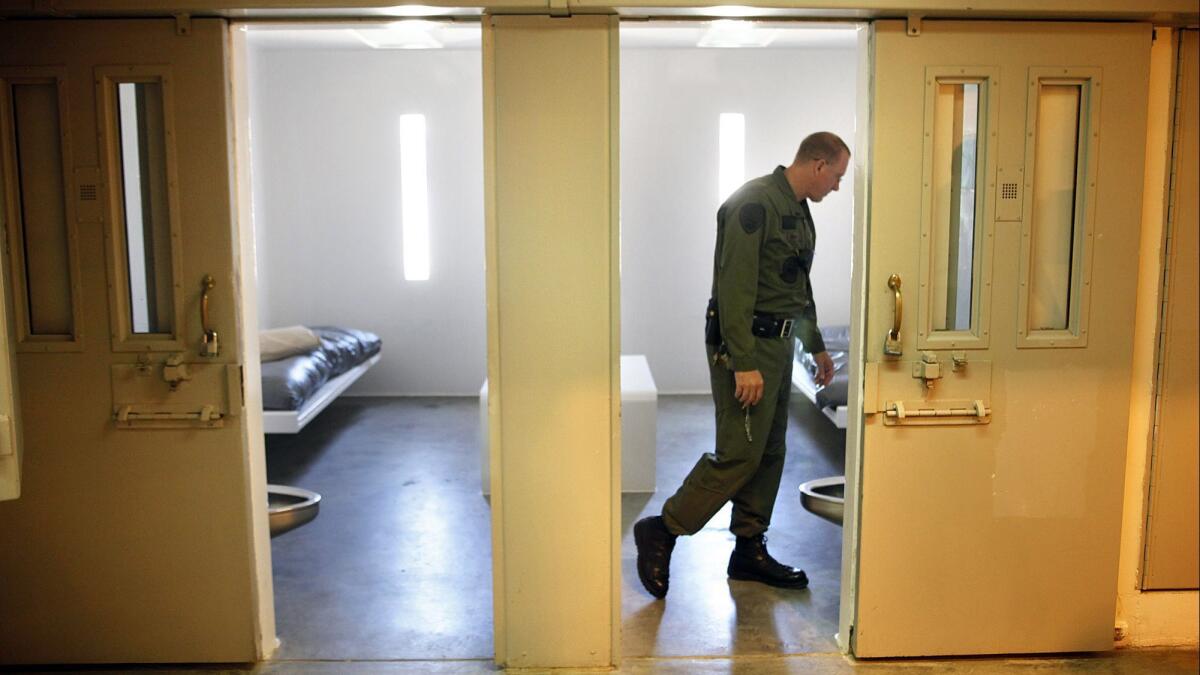 In this 2010 file photo, an investigative official looks inside a single-occupancy cell in Facility C Housing Unit 6 at Salinas Valley State Prison in Soledad. Monday's riot broke out in the Facility C unit day rooms.